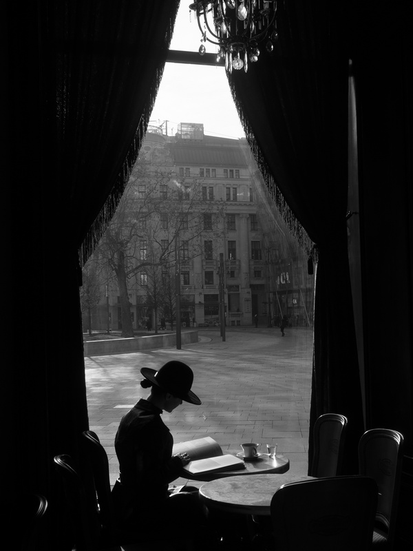 Woman in Window of Budapest Cafe Reading a Book